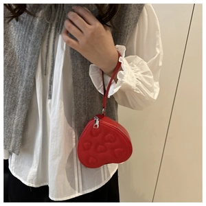 Detail of red heart-shaped PU leather coin purse with embossed pattern and wrist strap