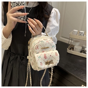 Close-up of mini floral bag with cute rabbit prints and golden FASHION metal plaque