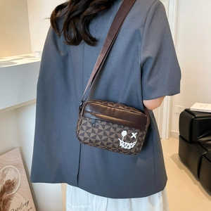 Brown geometric crossbody bag with graffiti smiley face and adjustable shoulder strap