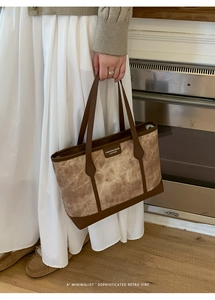 Detail of a large brown marble texture tote bag with leather handles in a cozy home setting