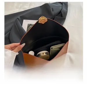 Pochette enveloppe marron avec fermoir magnétique montrant un intérieur spacieux