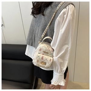Close-up of mini tweed backpack featuring cute rabbit prints and gold twist lock clasp