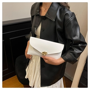 Vue détaillée de la pochette enveloppe en cuir blanc avec une boucle dorée en forme de cœur