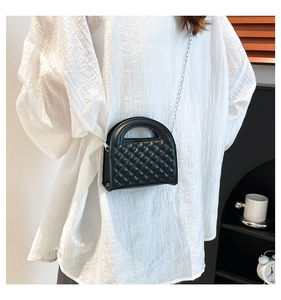 Close-up of black quilted chain crossbody bag with glossy PU leather and diamond pattern