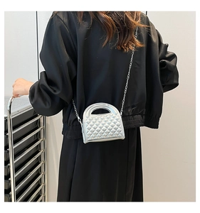 Silver quilted chain bag shown on model with metallic finish and diamond pattern