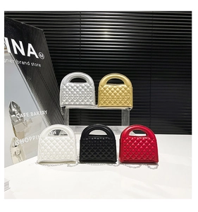 Detail view of five colors of quilted mini chain bags on transparent acrylic stands