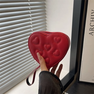 Compact red heart-shaped coin purse with quilted leather texture and a handy wrist strap