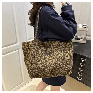 Close-up of leopard print canvas tote bag on model's shoulder in interior setting