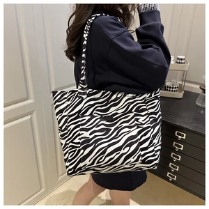 Detailed view of the large zebra print canvas tote bag on model for scale