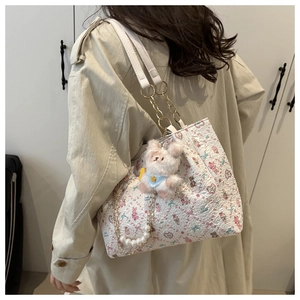 Détail du sac cabas floral avec chaîne en perles et adorable breloque lapin en peluche
