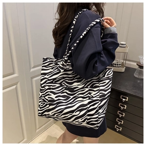 Side view of model wearing a large zebra print canvas tote bag for daily commute