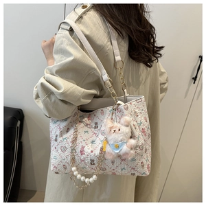 Détail du sac cabas blanc avec charm ours en peluche et décoration de chaîne en perles