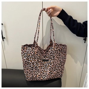 Close-up of pink leopard print tote bag with black label and dual shoulder straps