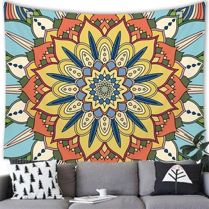 Detail of vibrant yellow mandala tapestry hanging above a sofa in a boho living room