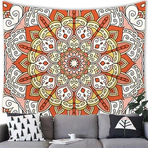 Detailed mandala wall tapestry with warm orange floral patterns hanging above a sofa