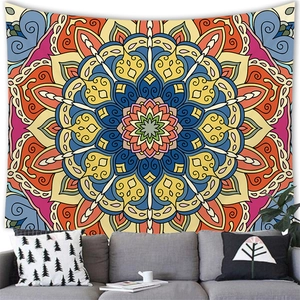Detailed close-up of a large bohemian mandala tapestry hanging over a grey fabric sofa