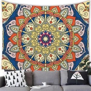 Ethnic mandala tapestry with geometric floral patterns hanging over a sofa in a living room