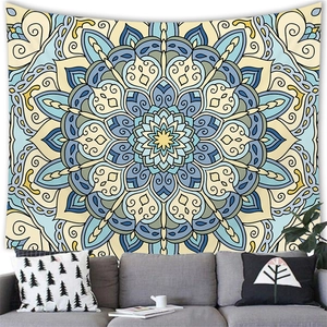 Ethnic mandala geometric tapestry in blue and yellow hanging over a modern grey sofa