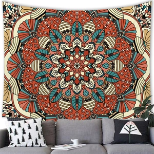 Modern bohemian mandala tapestry hanging on wall above a grey sofa in living room decor