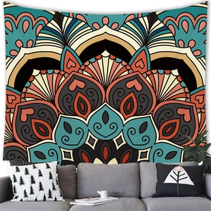 Detail of bohemian mandala tapestry hanging above a grey sofa with decorative pillows