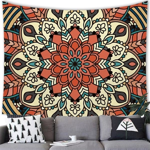 Detail of warm orange bohemian mandala tapestry showing intricate floral patterns on a wall