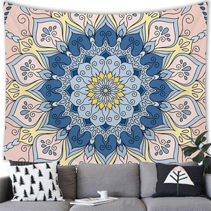Bohemian mandala tapestry with radial geometric patterns hanging above a modern sofa