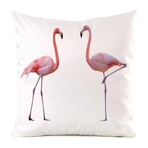 Detailed view of pink flamingos printed on a white faux silk decorative cushion cover