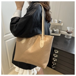 Detail of light beige woven tote bag shown on model for size and style reference