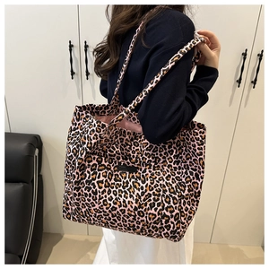 Detailed side view of large pink leopard print canvas tote bag with front pocket