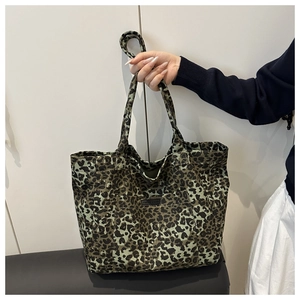 Close-up of leopard print canvas tote bag featuring double handles and front pocket