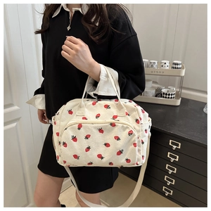 Detail of cream corduroy tote bag with strawberry print and adjustable shoulder strap