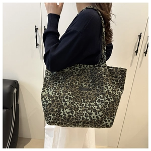 Detail of the leopard print canvas tote bag featuring an outer pocket and large capacity