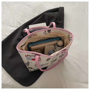 Spacious interior of graffiti tote bag showing iPad, books and travel essentials