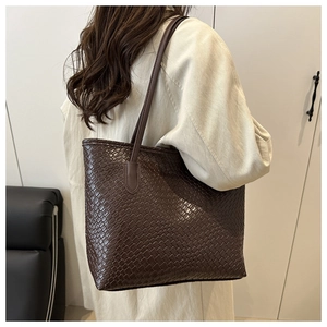Detail of the large dark brown woven tote bag featuring high-quality leather texture