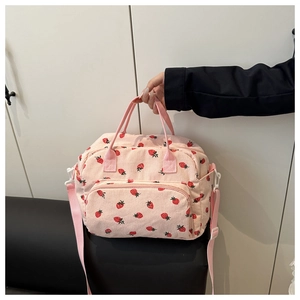 Detailed close-up of pink corduroy handbag with sweet strawberry print and front pocket