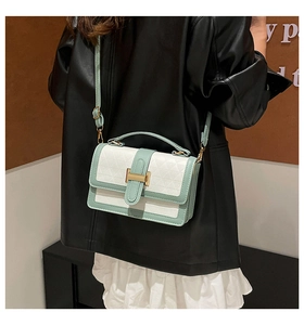 Detail view of the mint green patchwork handbag with quilted texture and gold metal buckle