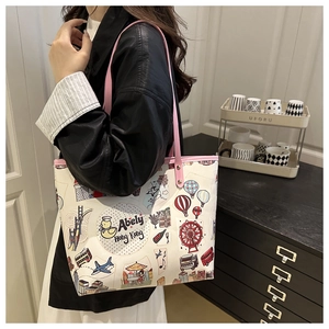 Vista dettagliata della borsa tote bianca con manici rosa e illustrazioni urbane colorate