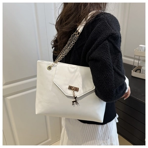 White shoulder tote bag with golden chain strap and reindeer pendant on model