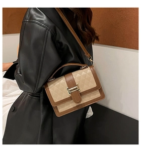 Detail of contrasting beige and brown shoulder bag with geometric triangle embossing