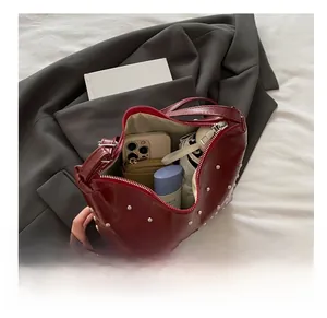 Detail showing the large interior capacity of this red studded bucket bag for daily essentials