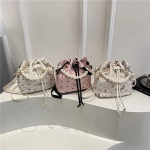 Chic bucket bags with pearl handles and bow ties in white, pink, and floral patterns