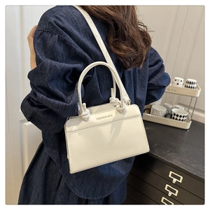 Detail of white leather shoulder bag with knot handle and Fashion Bag lettering