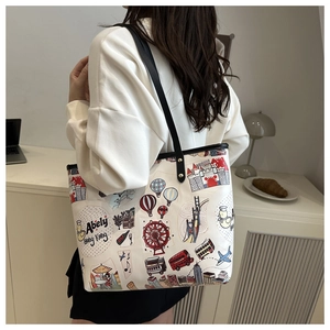 Dettaglio della borsa tote bianca con illustrazioni di viaggio e tracolla in pelle nera