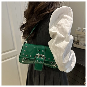 Detail of dark green patent leather shoulder bag with silver studs and buckles