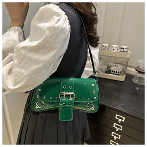 Détail du sac sous le bras en cuir verni vert avec rivets argentés et boucle en métal