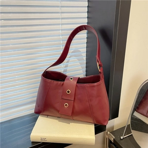 Minimalist burgundy faux leather shoulder bag with gold ring accents and wide buckle strap