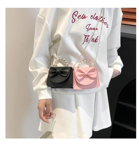 Detailed view of mini crossbody bags with bow design and pearl handles in black and pink