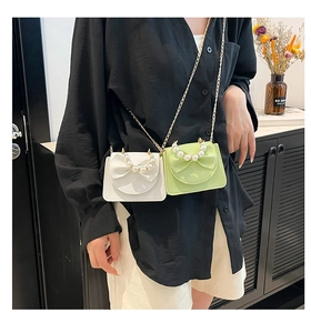 Mini crossbody bags with pearl handle and bow design in white and green leather