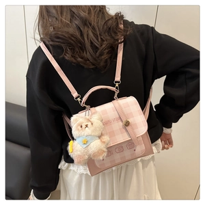 Pink and white checkered handbag featuring a plush bear charm and cartoon graphics