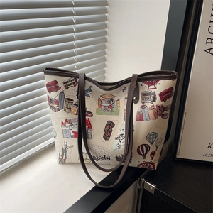 Travel-themed graffiti printed tote bag with leather handles and long shoulder strap